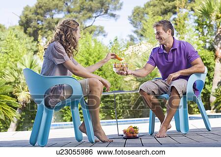 Couple on a wooden terrace by a pool View Large Photo Image Stock Photograph - Couple on a wooden terrace by a pool. Fotosearch