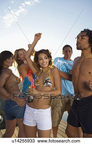 Stock Image - Men and women dancing on terrace. Fotosearch