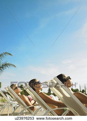 Three ladies relaxing in the sun View Large Photo Image Stock Image - Three ladies relaxing in the sun . Fotosearch