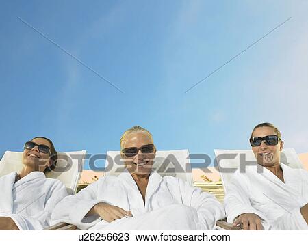 Three ladies relaxing in the sun View Large Photo Image Stock Image - Three ladies relaxing in the sun. Fotosearch