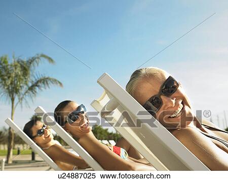 Three ladies relaxing in the sun View Large Photo Image Stock Photography - Three ladies relaxing in the sun. Fotosearch