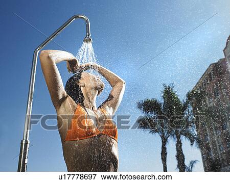 Stock Photo - Woman having out door shower . Fotosearch