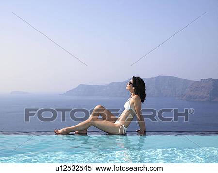 Woman sitting on the edge of a pool View Large Photo Image Stock Photography - Woman sitting on the edge of a pool. Fotosearch