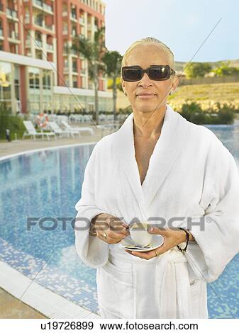 Stock Photo - Woman with coffee cup by pools edge . Fotosearch