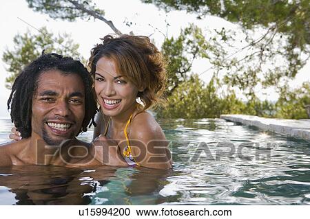 Stock Image - Young man and woman in a pool. Fotosearch