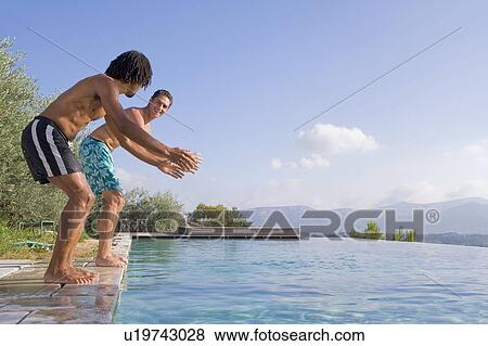 Stock Photo - Young men diving into a pool. Fotosearch