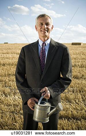 Stock Image - Businessman in a wheat field.. Fotosearch