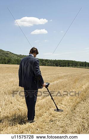 Businessman with metal detector outdoors. View Large Photo Image Stock Photo - Businessman with metal detector outdoors.. Fotosearch