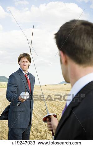 Businessmen fencing in wheat field. View Large Photo Image Stock Image - Businessmen fencing in wheat field.. Fotosearch