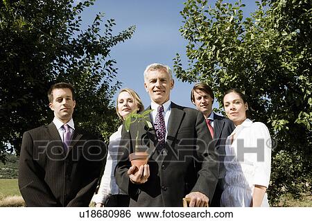 Stock Photograph - Group of businesspeople in an orchard.. Fotosearch