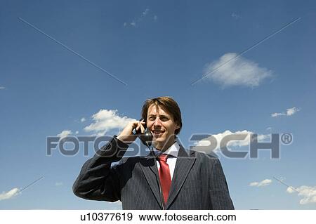 Man holding old phone against blue sky. View Large Photo Image Stock Photo - Man holding old phone against blue sky.. Fotosearch
