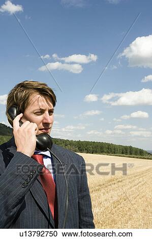 Stock Image - Man on old phone in wheat field.. Fotosearch
