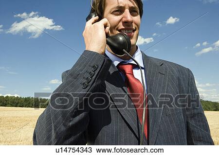 Man on old phone in wheat field. View Large Photo Image Stock Image - Man on old phone in wheat field.. Fotosearch
