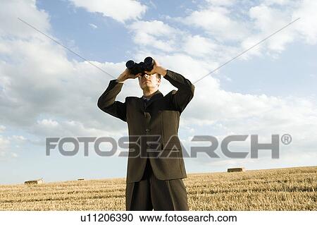 Man using binoculars in wheat field. View Large Photo Image Stock Image - Man using binoculars in wheat field.. Fotosearch