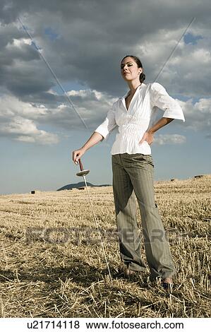 Stock Photo - Woman standing with sword in wheat field.. Fotosearch