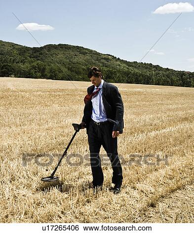 Businessman with metal detector outdoors. View Large Photo Image Stock Photograph - Businessman with metal detector outdoors.. Fotosearch