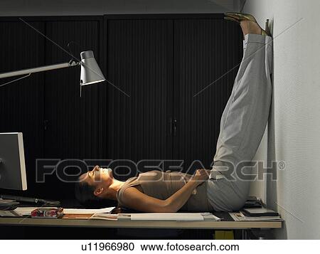 Businesswoman lying on her back on her desk View Large Photo Image Stock Image - Businesswoman lying on her back on her desk. Fotosearch