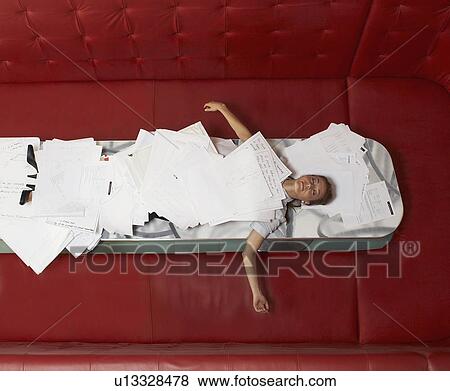 Stock Photo - Businesswoman lying on table with red seating. Fotosearch