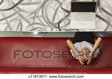 Businesswoman working at a table with red seating View Large Photo Image Stock Image - Businesswoman working at a table with red seating. Fotosearch