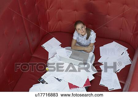 Businesswoman working at a table with red seating View Large Photo Image Stock Image - Businesswoman working at a table with red seating. Fotosearch
