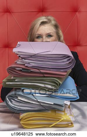 Stock Photography - Businesswoman working at a table with red seating. Fotosearch