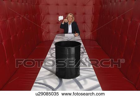 Stock Photography - Businesswoman working at a table with red seating. Fotosearch