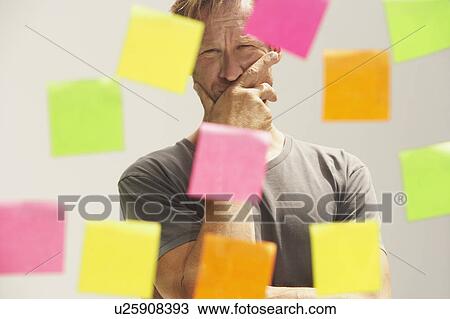 Man looking at a window with colored PostIt Notes. View Large Photo Image Stock Image - Man looking at a window with colored PostIt Notes.. Fotosearch