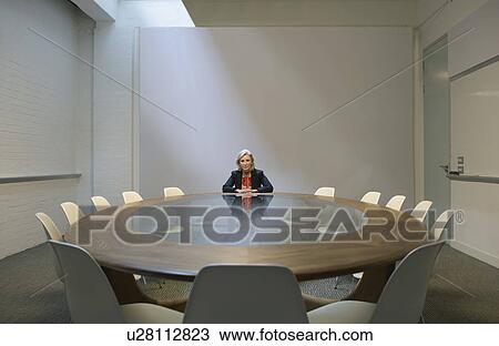 Woman seated in boardroom alone View Large Photo Image Stock Image - Woman seated in boardroom alone. Fotosearch
