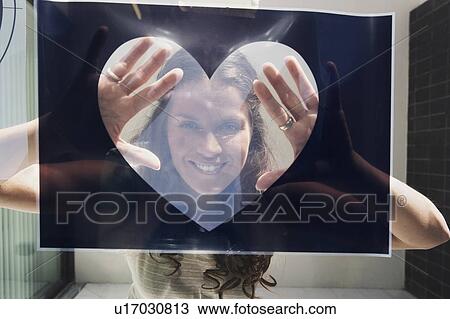 Young woman seen through heart shaped graphic. View Large Photo Image Stock Image - Young woman seen through heart shaped graphic.. Fotosearch