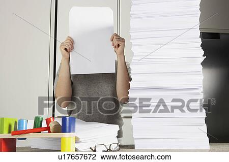 Young woman working from home with huge pile of paper. View Large Photo Image Stock Image - Young woman working from home with huge pile of paper.. Fotosearch