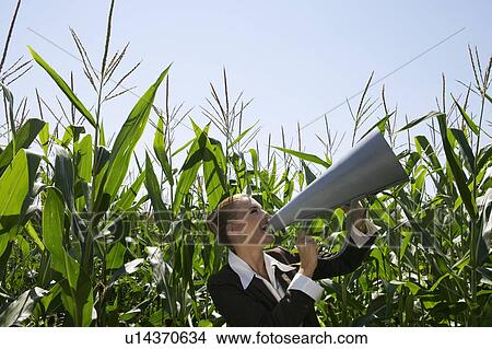 Business women shouting into megaphone in corn field. View Large Photo Image Picture - Business women shouting into megaphone in corn field.. Fotosearch