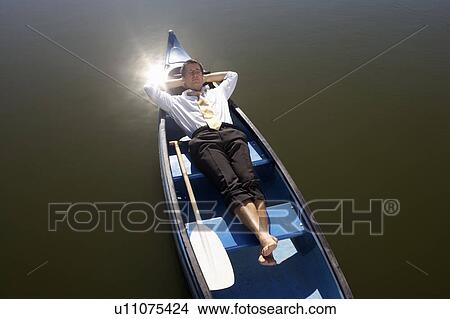 Picture - Businessman asleep in canoe.. Fotosearch