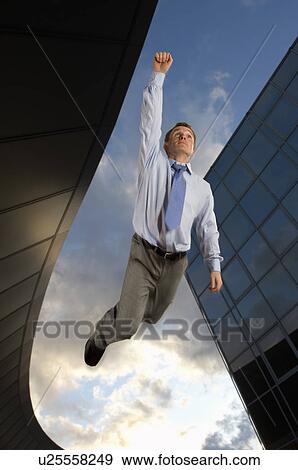 Businessman flying overtop of the city View Large Photo Image Stock Photo - Businessman flying overtop of the city. Fotosearch
