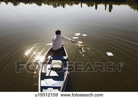 Businessman in canoe with fishing net. View Large Photo Image Stock Photo - Businessman in canoe with fishing net.. Fotosearch