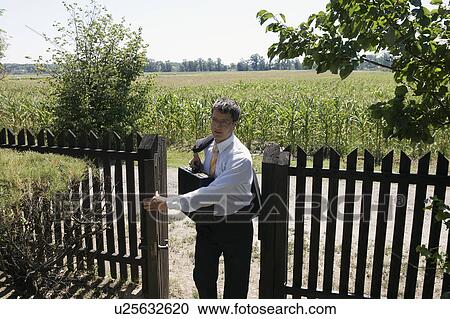 Stock Image - Businessman opening gate.. Fotosearch