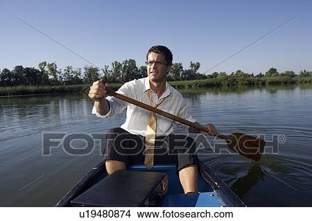 Businessman rowing in canoe. View Large Photo Image Picture - Businessman rowing in canoe.. Fotosearch