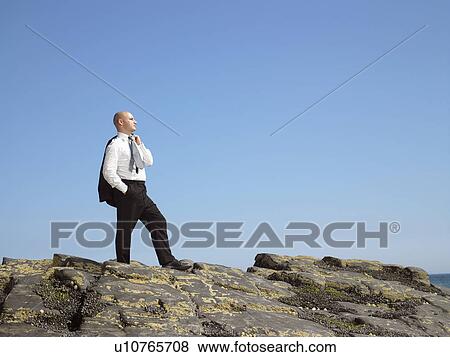 Businessman standing on rock. View Large Photo Image Stock Photo - Businessman standing on rock.. Fotosearch
