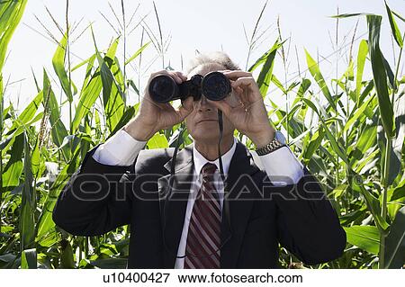 Businessman with binoculars in cornfield. View Large Photo Image Stock Photo - Businessman with binoculars in cornfield.. Fotosearch