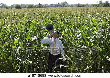 Businessman with megaphone in cornfield. View Large Photo Image Stock Photo - Businessman with megaphone in cornfield.. Fotosearch