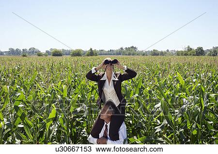 Stock Image - Businesswoman on businessman's shoulders with megaphone.. Fotosearch
