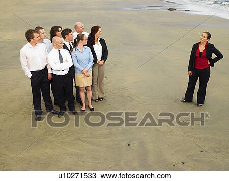 Stock Image - Group of businesspeople on the beach.. Fotosearch
