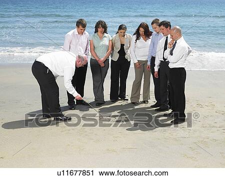 Stock Image - Group of businesspeople on the beach.. Fotosearch