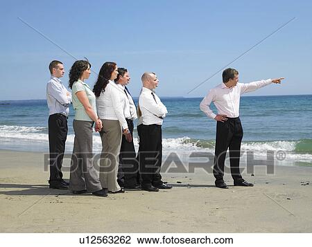 Stock Image - Group of businesspeople on the beach.. Fotosearch