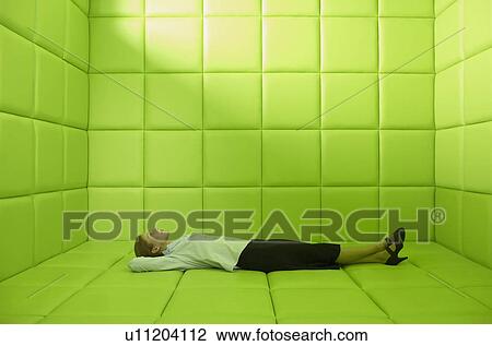 Stock Image - Woman lying in green padded cell. Fotosearch