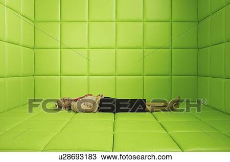 Stock Image - Woman resting in green padded cell. Fotosearch
