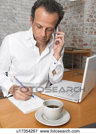 Businessman on the phone, taking notes. Brussels, Belgium. View Large Photo Image Stock Photo - Businessman on the phone, taking notes. Brussels, Belgium.. Fotosearch
