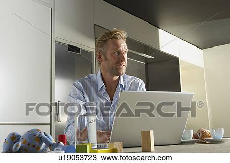 Stock Image - Businessman working from home.. Fotosearch