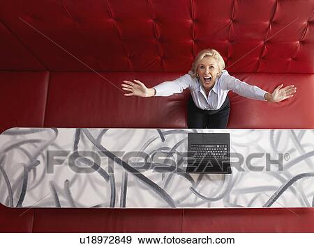 Businesswoman working at a table with red seating View Large Photo Image Stock Photo - Businesswoman working at a table with red seating. Fotosearch