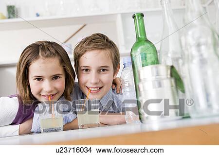 Boy and girl drinking lemonade, smiling View Large Photo Image Picture - Boy and girl drinking lemonade, smiling. Fotosearch