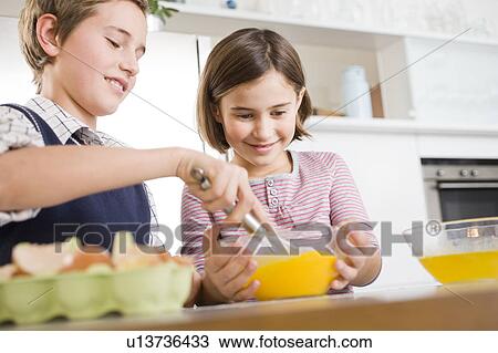 Boy and girl stirring egg yolk together View Large Photo Image Stock Image - Boy and girl stirring egg yolk together. Fotosearch